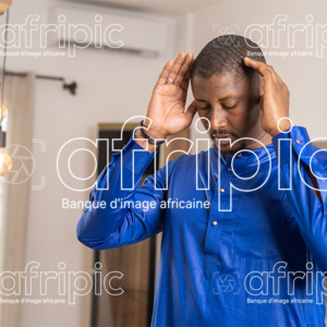 Jeune homme africain musulman , en tenue traditionnelle qui prie.