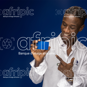 Jeune homme africain souriant en tenue moderne tenant une carte à la main