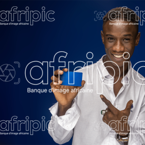 Jeune homme africain  souriant en tenue moderne tenant une carte à la main