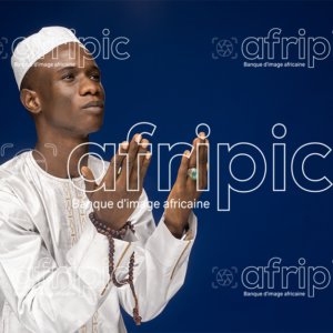 Jeune africain musulman en tenue traditionnelle faisant des prières