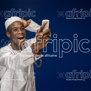 Jeune homme africain heureux et excité tenant un téléphone