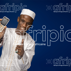 Jeune homme africain souriant et amical avec un téléphone à la main