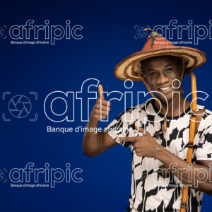 Jeune africain paysan, heureux et amical tenant une canne.