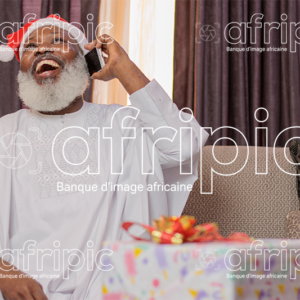 Homme africain senior, heureux en communication téléphonique, en période de fête