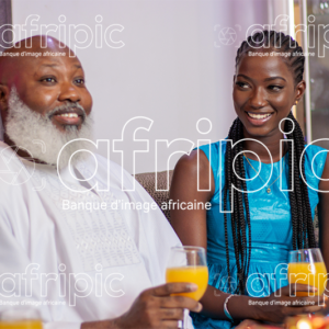 Père et fille heureux entretenant une discussion, en buvant du jus.