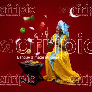 Jeune femme africaine toute heureuse, faisant de la grillade pour la Tabaski
