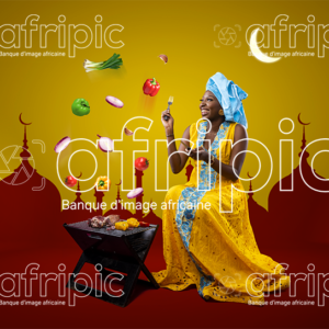 Jeune femme africaine toute heureuse, faisant de la grillade pour la Tabaski