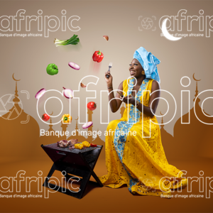 Jeune femme africaine toute heureuse, faisant de la grillade pour la Tabaski