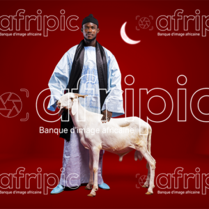 Jeune homme africain en tenue traditionnelle avec son mouton de tabaski