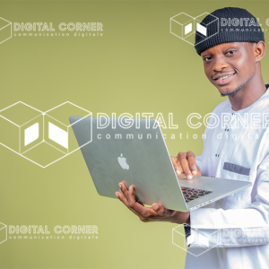 Jeune homme africain en tenue traditionnelle avec un ordinateur à la main. Technologie, Informatique, Vente en ligne, Commerce en ligne, E-learning