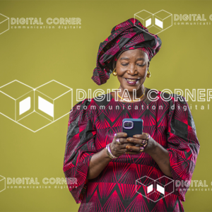 Femme Senior Africaine avec un téléphone à la main. Technologie, Informatique, transfert d’argent, Commerce en ligne, E-learning, Tenue traditionnelle