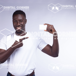 Jeune homme africain souriant, en tenue moderne, avec une carte à la main. Banque, Informatique, transfert d’argent, Scan, paiement en ligne