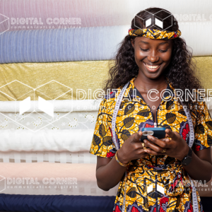 Jeune couturière africaine souriante, tenant un téléphone