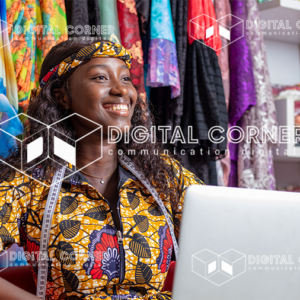Jeune couturière africaine souriante tenant un ordinateur